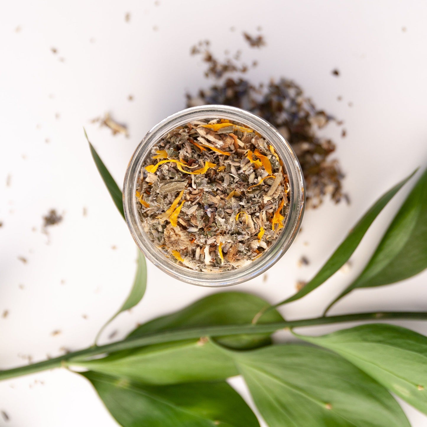 Overhead shot of open Herbal Facial Steam 1.25 ounce clear glass jar. By Slow North